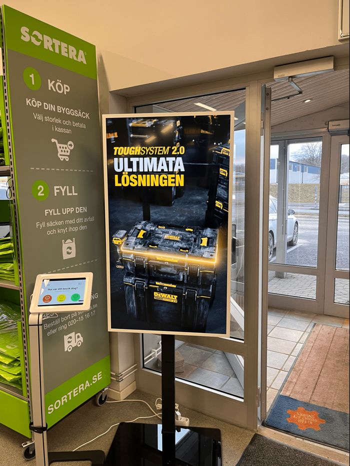 Stående digital skärm med kampanj vid butiksentrén