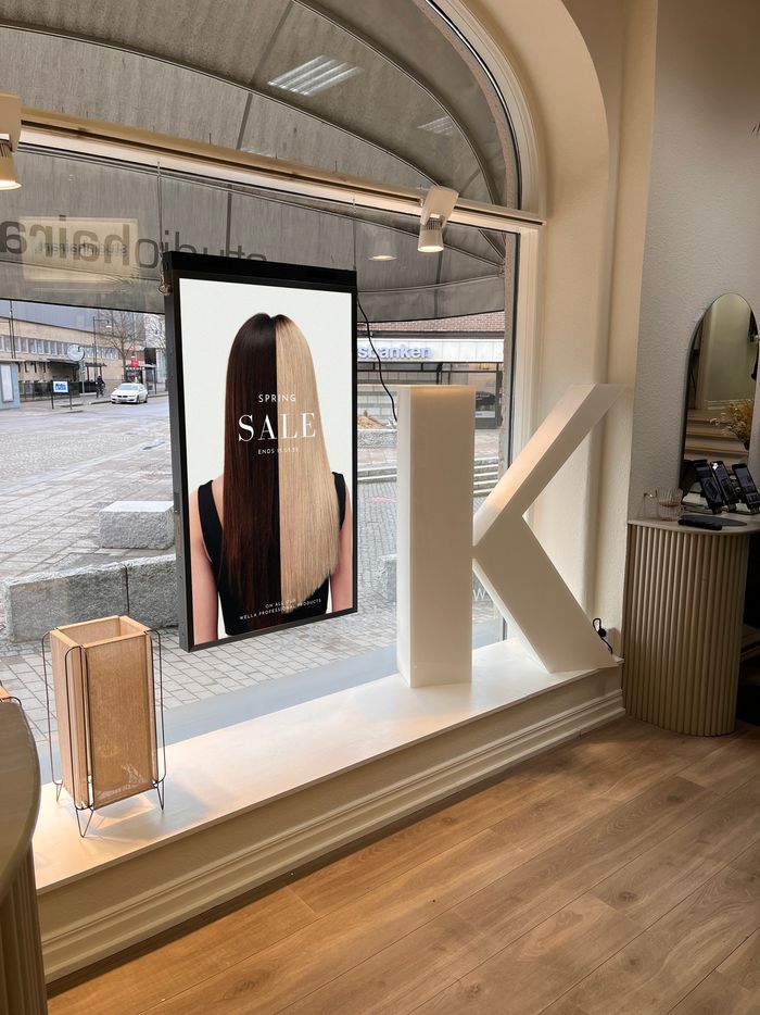 Stående skärm i skyltfönstret hos Studio Hair Art