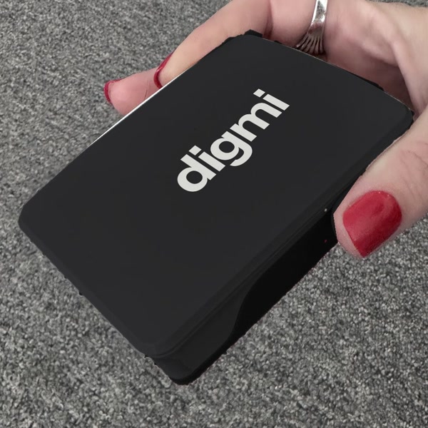 Digmi Box i svart skal med vit Digmi-logga, i en hand